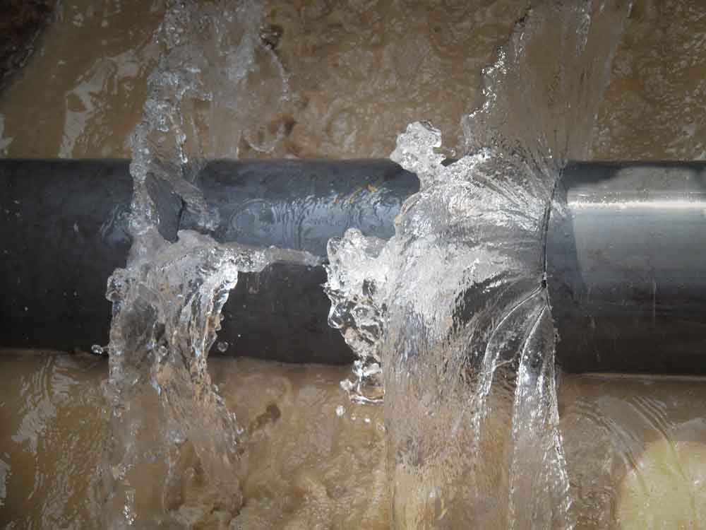 Close Up Image Of Burst Pipe And Leaking Water