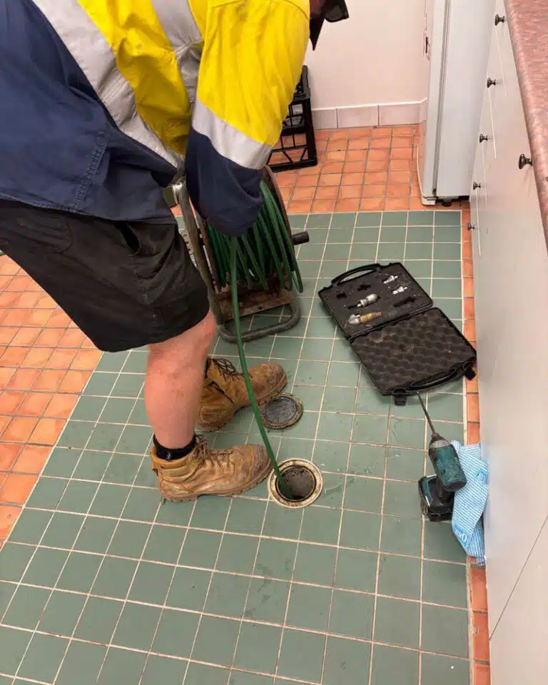 Man in Workwear Doing Maintenance on Drain